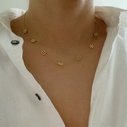 Collar delicado con flor de cuentas doradas