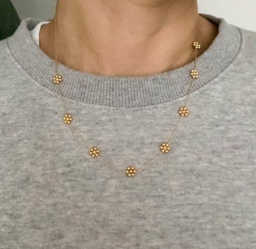 Collar delicado con flor de cuentas doradas