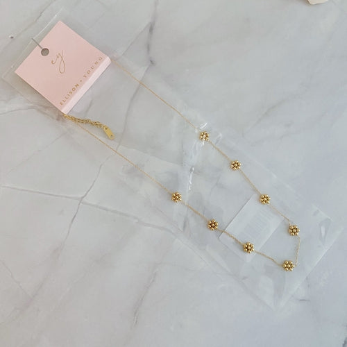 Collar delicado con flor de cuentas doradas